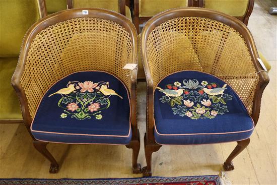 Pair of caned mahogany bergeres with claw and ball feet, fitted loose tapestry cushions